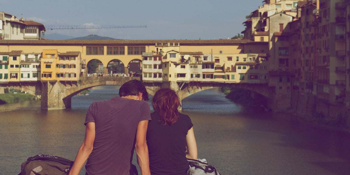 back of man and woman looking over a river